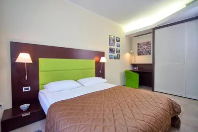 a bedroom with a large bed with a green headboard at Apartma Anka *** in Kranjska Gora