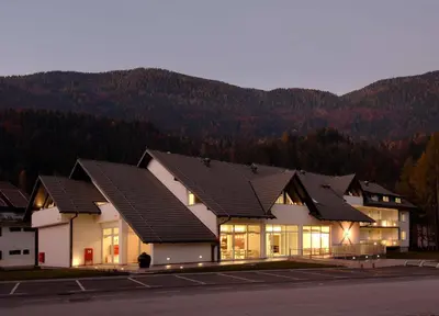 a building with windows with mountains in the background at Apartma Anka *** in Kranjska Gora