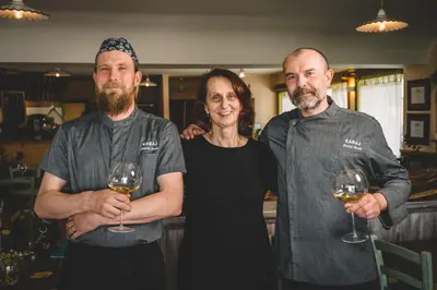 a woman and two men holding glasses of wine at KABAJ Wine & Dine in Dobrovo
