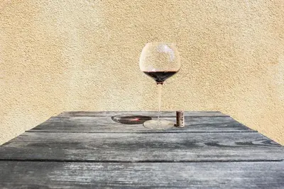 a glass of wine sitting on top of a wooden table at KABAJ Wine & Dine in Dobrovo