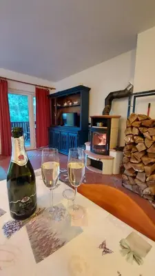 two glasses of wine sitting on a table in a living room at Rogla Apartma Kekec in Zreče
