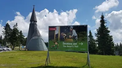 a sign in the middle of a field with a tower at Rogla Apartma Kekec in Zreče