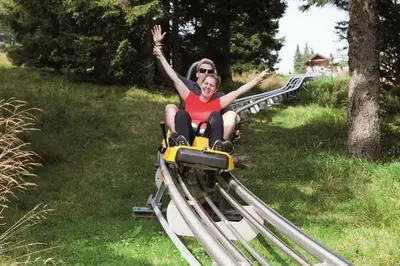 a woman and a girl riding on a roller coaster at Rogla Apartma Kekec in Zreče