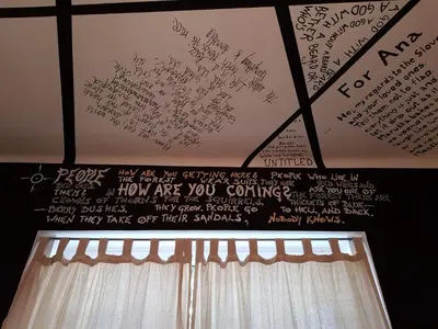 a wall with writing on the ceiling with a curtain at Villa Coola in Ljubljana