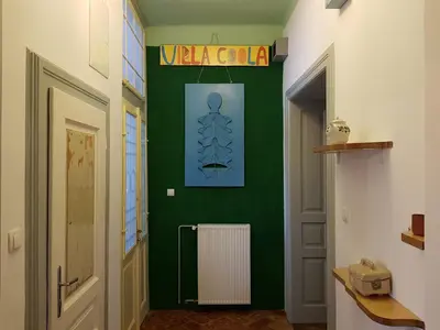 a hallway with a green wall with a sign on it at Villa Coola in Ljubljana