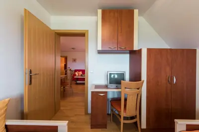 a kitchen with a table and a tv in a room at Apartments Moravske Toplice in Moravske Toplice