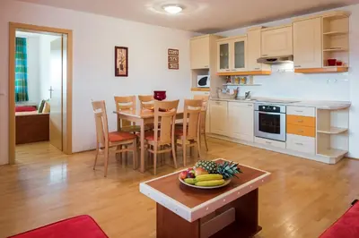 a kitchen and dining room with a bowl of fruit on a table at Apartments Moravske Toplice in Moravske Toplice
