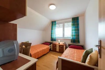 a small room with two beds and a tv at Apartments Moravske Toplice in Moravske Toplice