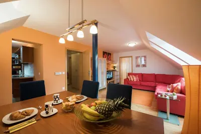 a dining room with a table and a red couch at Apartments Moravske Toplice in Moravske Toplice