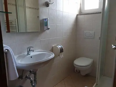 a bathroom with a sink and a toilet at Dežman Apartments & Rooms in Kranj