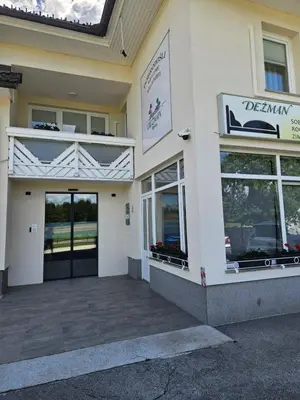 a facade of a building with a sign on it at Dežman Apartments & Rooms in Kranj