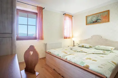 a bedroom with a bed and a window at Apartments Tourist farm Matijovc in Naklo