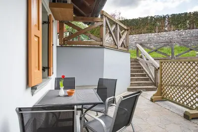 a patio with a table and chairs and a staircase at Apartments Tourist farm Matijovc in Naklo