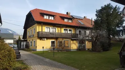 a yellow house with a red roof at Resort Vidmar - Apartments Vidmar near Bled in Lesce