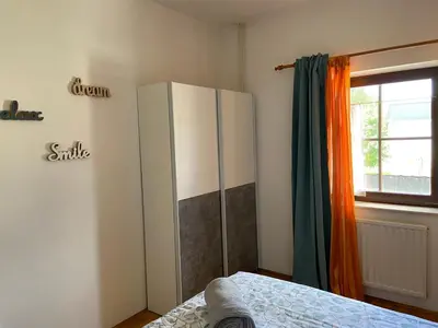 a bedroom with a white cabinet and a window at Resort Vidmar - Apartments Vidmar near Bled in Lesce