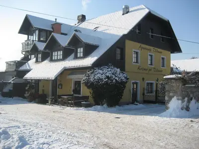 a large yellow and black building in the snow at Resort Vidmar - Apartments Vidmar near Bled in Lesce