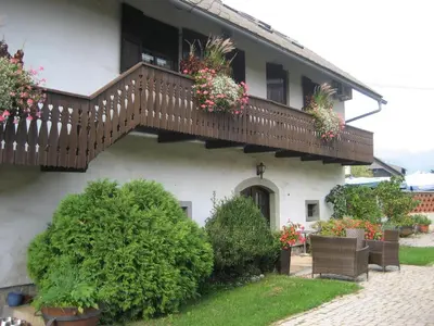 a house with a balcony with flowers on it at Resort Vidmar - Apartments Vidmar near Bled in Lesce