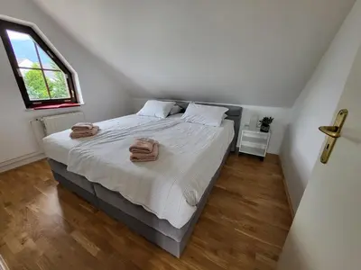 a bedroom with a bed with two towels on it at Resort Vidmar - Apartments Vidmar near Bled in Lesce