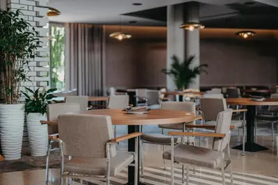 a restaurant with tables and chairs and plants at Hotel Terme - Terme Čatež in Čatež ob Savi