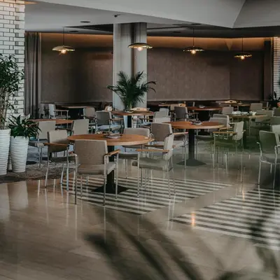 a restaurant with tables and chairs in a room at Hotel Terme - Terme Čatež in Čatež ob Savi