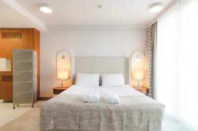 a bedroom with a large white bed with two lamps at Hotel Terme - Terme Čatež in Čatež ob Savi