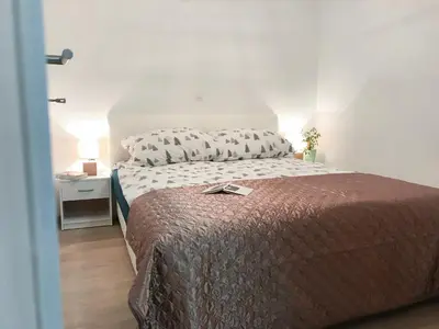 a bedroom with a bed with a brown blanket and pillows at Apartment Tosca near Vintgar and Lake Bled in Zgornje Gorje
