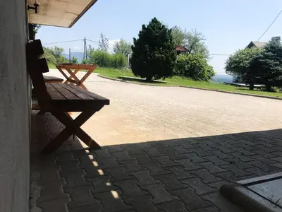 a wooden bench sitting on the side of a patio at Apartment Tosca near Vintgar and Lake Bled in Zgornje Gorje
