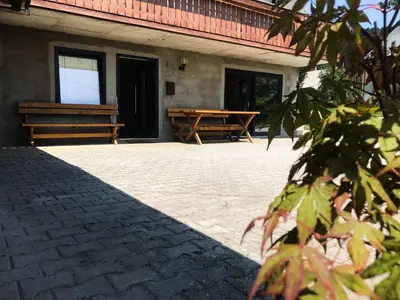 a patio with two benches and a table at Apartment Tosca near Vintgar and Lake Bled in Zgornje Gorje
