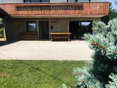 a patio with two benches and a wooden table at Apartment Tosca near Vintgar and Lake Bled in Zgornje Gorje