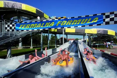 a group of people riding a water slide at a water park at Apartments Čatež - Terme Čatež in Čatež ob Savi