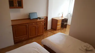 a room with two beds and a desk with a computer on it at Marinčič Inn in Škocjan