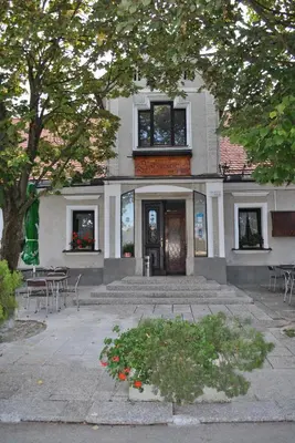 a building with tables and chairs in front of it at Marinčič Inn in Škocjan