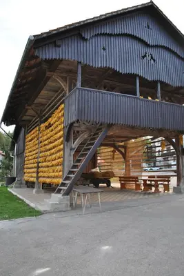 a large wooden building with a staircase in it at Marinčič Inn in Škocjan