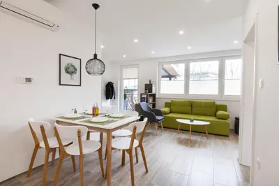 a living room with a table and a green couch at Felix apartment Tour As Ljubljana in Ljubljana