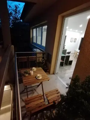 a balcony with a wooden table and chairs on a patio at Felix apartment Tour As Ljubljana in Ljubljana