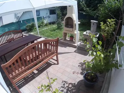 a patio with a wooden bench and an outdoor oven at The Place in Ljubljana