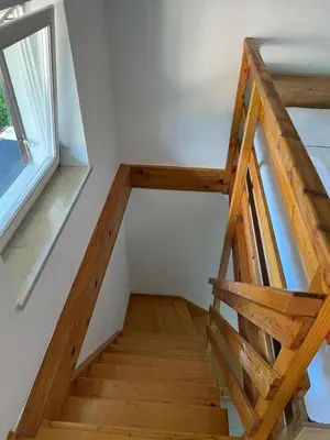 a wooden staircase in a house with a window at Cosy cottage with views near Kobarid in Kobarid