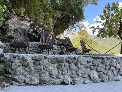 three chairs sitting on top of a stone wall at Cosy cottage with views near Kobarid in Kobarid