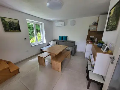 a living room with a table and a couch at Cosy cottage with views near Kobarid in Kobarid