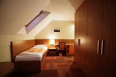 a bedroom with a bed and a desk in it at Hotel Marinšek in Naklo
