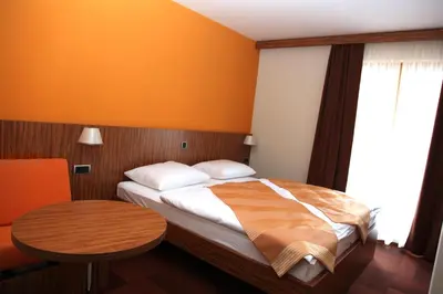 a bedroom with a bed and a table and a window at Hotel Marinšek in Naklo