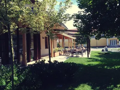 a house with tables and chairs in a yard at Hotel Marinšek in Naklo