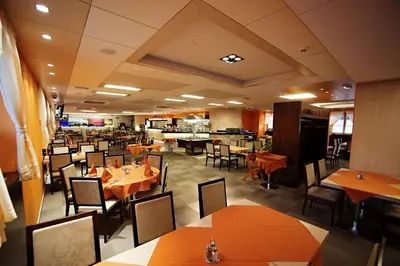 a dining room with tables and chairs in a restaurant at Hotel Marinšek in Naklo