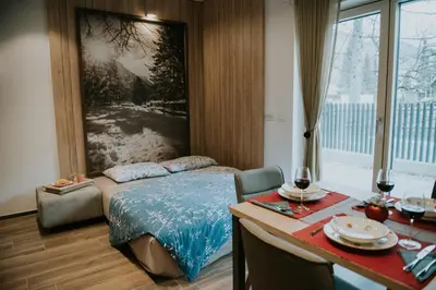 a bedroom with a bed and a table and a table sidx sidx sidx at Villa Mojca - Jasna&Jelka Apartments, Central Location with Private Garage and Alpine View in Kranjska Gora