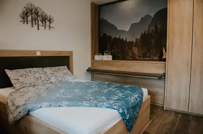 a bedroom with a bed with a picture on the wall at Villa Mojca - Jasna&Jelka Apartments, Central Location with Private Garage and Alpine View in Kranjska Gora