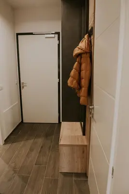 a hallway with a white door and a wooden floor at Villa Mojca - Jasna&Jelka Apartments, Central Location with Private Garage and Alpine View in Kranjska Gora