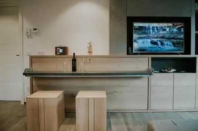 a bar with a bottle of wine and a television at Villa Mojca - Jasna&Jelka Apartments, Central Location with Private Garage and Alpine View in Kranjska Gora