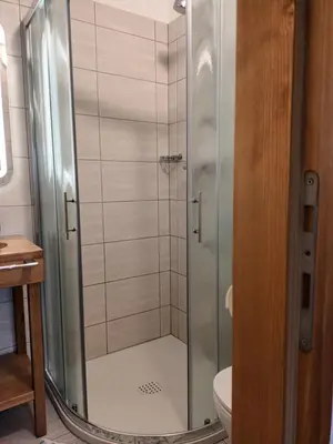 a shower with a glass door in a bathroom at APARTMA ANA IDA in Srpenica
