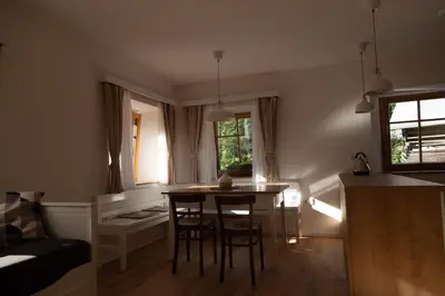 a kitchen and living room with a table and chairs at Apartments Tourist Farm Štorman with EV Ch-Station in Tržič