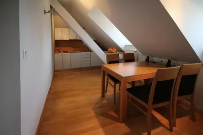 a kitchen and dining room with a table and chairs at Apartments Villa Boltez in Kranj